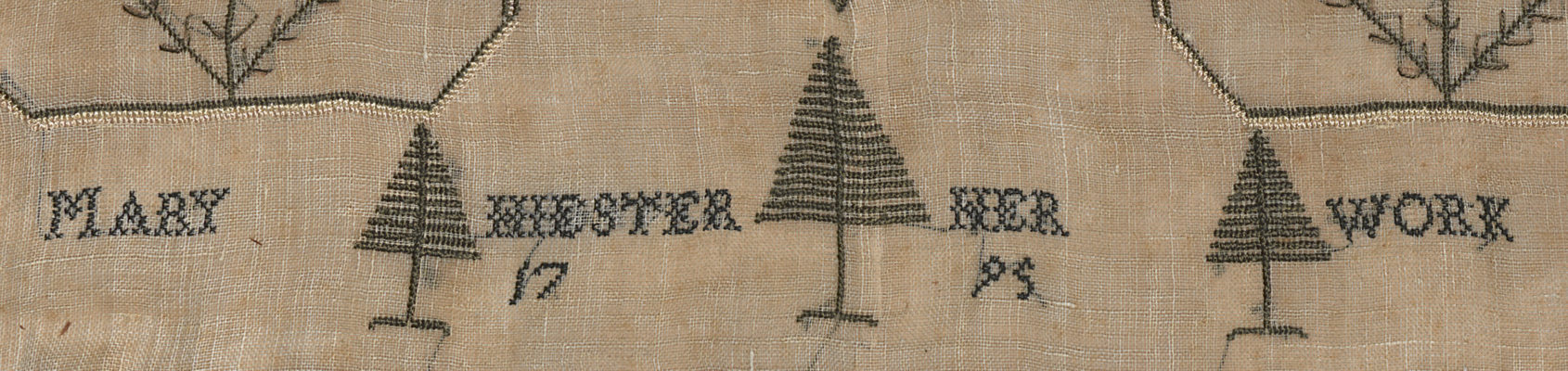 Detail of sampler with embroidered phrase.