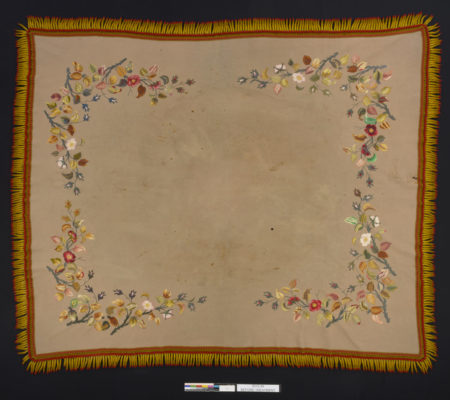 Full table cover. Plain center surrounded by detailed and colorful floral embroidery.
