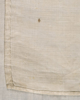 Detail of stitches on the handkerchief. Larger and sloppier stitches on the left hem. Smaller and neater stitches on the bottom hem.